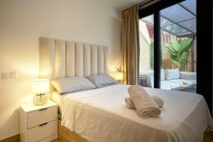 a bedroom with a large white bed with a window at La huerta centro in Alicante +51 photos