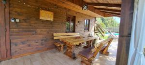 a wooden cabin with a wooden table and benches at Kuća za odmor Mirna Zagorka in Igrišće