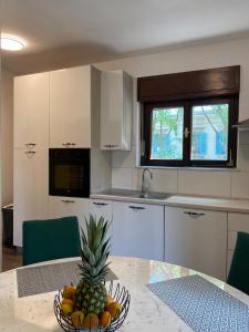 a kitchen with a pineapple in a bowl on a table at SLAVANTE RESIDENCE in Rijeka