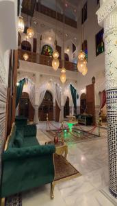 a living room with green furniture and chandeliers at Riad Jnane Fes Medina & Luxury Palace in Fès