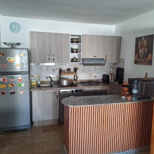 a kitchen with a refrigerator and a counter top at Malaga Beach in Mansouria