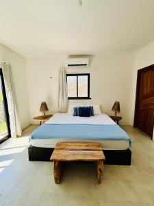 a bedroom with a large bed and a wooden table at Barra Beach House in Fortim +165 photos