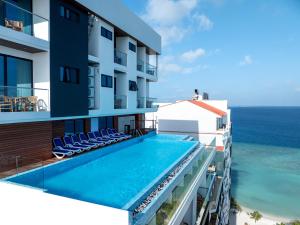 a view of a hotel with a swimming pool and the ocean at Arena Beach Hotel in Maafushi