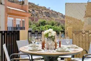 a table with glasses and flowers on a balcony at La huerta centro in Alicante