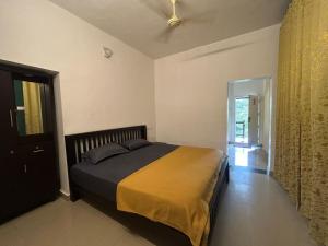 a bedroom with a bed with a yellow and black blanket at Le paradiso in Marayoor