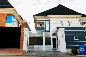 a white house with a black and white garage at Spacious 4-Bedroom Apartment shortlet, Allen Avenue ikeja in Ikeja