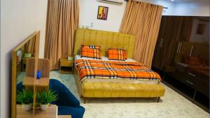 a bedroom with a yellow bed with orange pillows at Spacious 4-Bedroom Apartment shortlet, Allen Avenue ikeja in Ikeja