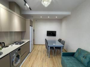 a kitchen and living room with a table and a couch at Family friendly in Baku