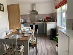 a kitchen with a wooden table with chairs and a dining room at The Firs, Frampton Lane, Boston, Lincolnshire, PE20 1SH in Boston