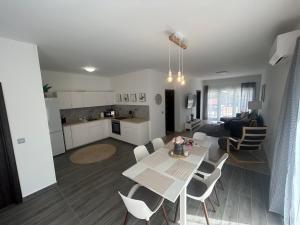 a kitchen and a living room with a table and chairs at Balaton Royal Residence Balatonfőkajár in Balatonfőkajár
