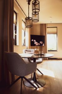 ein Wohnzimmer mit einem Tisch und einem Stuhl in der Unterkunft Bij Corine, bed en zorg in Altforst