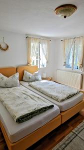 two beds in a bedroom with two windows at Alte Bleiche Lengefeld in Lengefeld