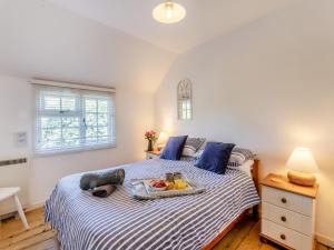 a bedroom with a bed with a tray of fruit on it at Island Cottage in West Mersea +10 photos