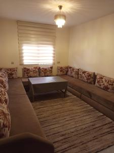 Una sala de estar con un sofá y una mesa de café. en Joli appartement 2 chambres à Agadir, en Agadir 1 foto más