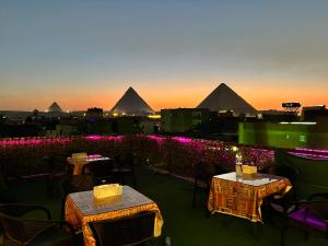 a view of the pyramids from a restaurant with tables at Jana pyramids view in 3 in Cairo