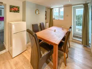 eine Küche und ein Esszimmer mit einem Holztisch und einem Kühlschrank in der Unterkunft Nemo's Lodge in Portland