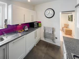 eine Küche mit weißen Schränken und einer Uhr an der Wand in der Unterkunft Nemo's Lodge in Portland