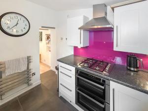 eine Küche mit einem Herd und einer Uhr an der Wand in der Unterkunft Nemo's Lodge in Portland + 20 Fotos