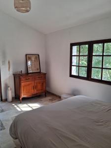 a bedroom with a bed and a dresser and windows at Appartement Atypique Corbières in Montséret