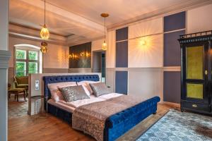 a bedroom with a blue bed in a room at Kaštieľ Nána in Nána