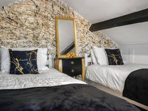 ein Schlafzimmer mit zwei Betten und einem Spiegel in der Unterkunft Heart Stone Cottage in Staithes