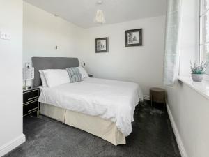 a white bedroom with a bed and a window at Cherry - Uk49174 in Burgh le Marsh