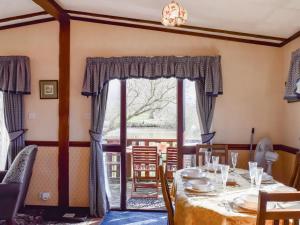 a dining room with a table and a window at Woodpecker Lodge - Uk49149 in Little Singleton