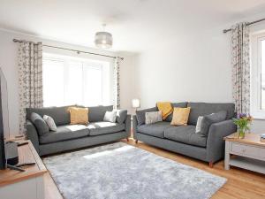 a living room with two couches and a rug at Fox Lodge in Crantock