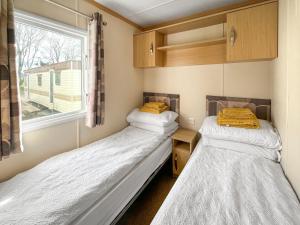 コッカーマスにあるThe Havenの窓のある小さな部屋にベッドが2つある +3枚の写真