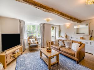 a living room with a couch and a tv at Barngarth in Cartmel