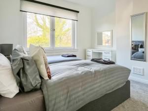 a bedroom with two beds and a window at Cambusmoon Apartment in Gartocharn +2 photos