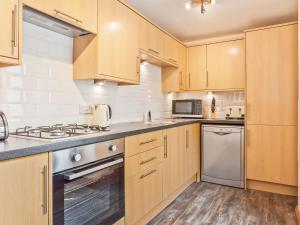 a kitchen with wooden cabinets and stainless steel appliances at Cove Lodge in Carnforth +10 photos