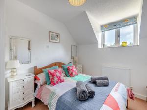 a bedroom with a bed and a dresser and windows at Gamekeepers Hide in Ivybridge +18 photos