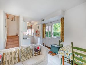 a living room with a white couch and a kitchen at Gamekeepers Hide in Ivybridge