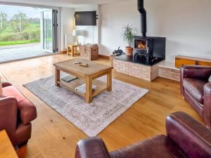 a living room with a coffee table and a fireplace at Poplars Cottage in Usk