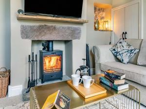 a living room with a fireplace and a table with books at Willoways in Bakewell +11 photos