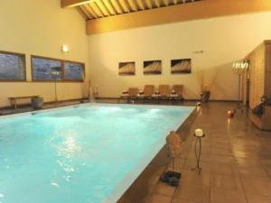 a large swimming pool in a large building at Sky High Family Apartment in Orelle