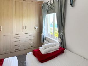 Un dormitorio con una cama con toallas rojas y blancas. en Sands, en Woolacombe