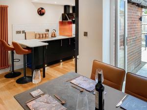 a kitchen with a table with a bottle of wine at Lily Pad - Uk49104 in Helmsley
