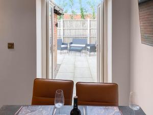 a dining table with two chairs and a door to a patio at Lily Pad - Uk49104 in Helmsley