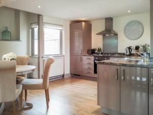 een keuken met een tafel en een aanrechtblad bij Woodlands View in Thorncombe