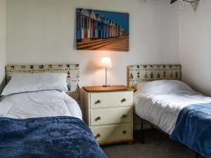 a bedroom with two beds and a night stand with a lamp at Sea La Vie in Bideford +5 photos