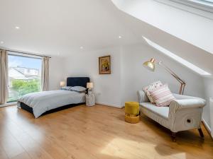 a bedroom with a bed and a chair and a window at Beach House in Seaford