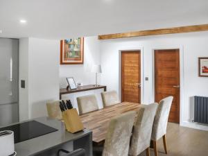 Un comedor con mesa y sillas de madera. en The Coach-House, en Tenby