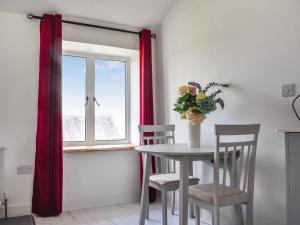 une table et des chaises dans une pièce avec une fenêtre dans l'établissement Beech Cottage - Uk49211, à Jacobstowe