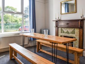 two wooden tables and benches in a room with a fireplace at 2 Le Dorney Villa - Uk49804 in Par