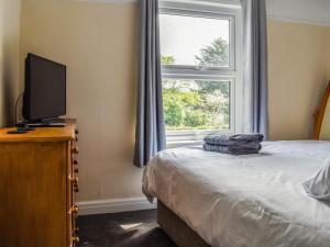 a bedroom with a bed and a television and a window at 2 Le Dorney Villa - Uk49804 in Par +12 photos