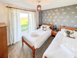 a bedroom with two beds and a window at Primrose Apartment - Uk49291 in Woolfardisworthy