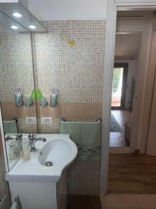 un bagno con un lavandino bianco e uno specchio di Villa Dea a Quartu Sant'Elena Altre 13 foto