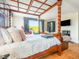 a bedroom with a large bed with a large window at The Old School in Ganton